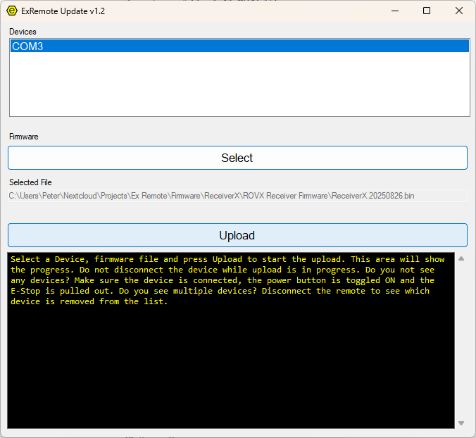 A screenshot of the windows application ExRemote Update where a COM port is selected in a list of devices, a file has been selected to be uploaded, and the Upload body highlighted to be pressed next. Below is a status windows with an instruction in yellow letters on a black background.